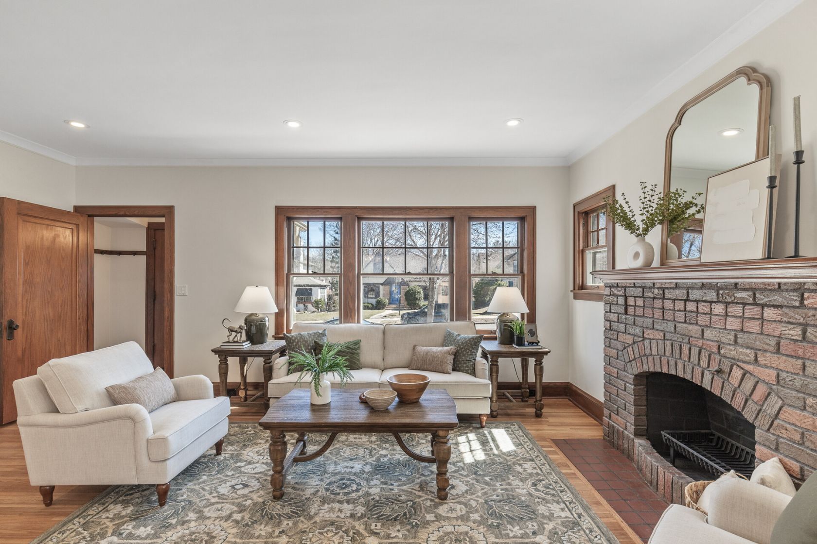 Staged living room with restored woodwork and arched mantle