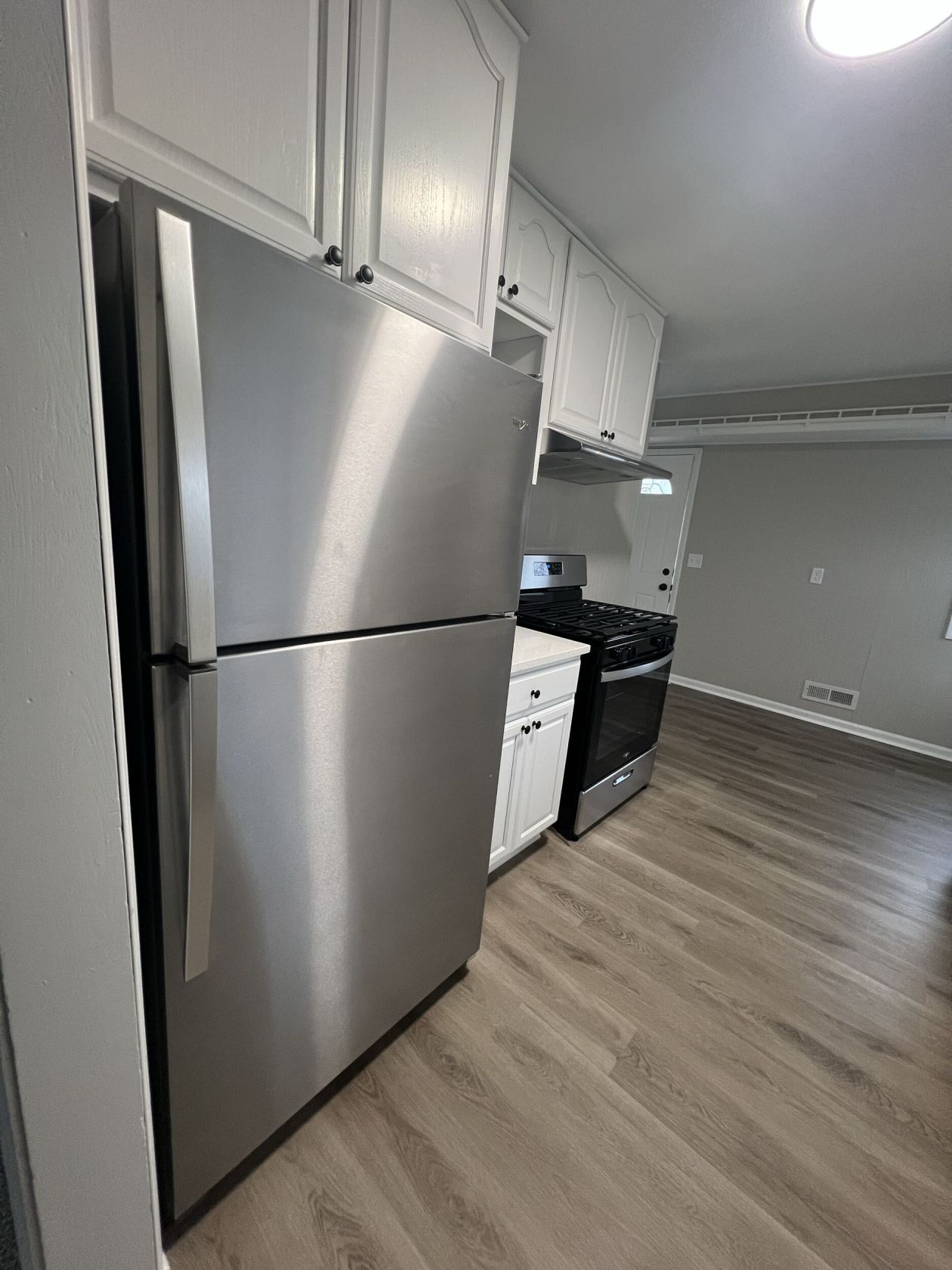 Stainless appliances against fresh paint and LVP flooring