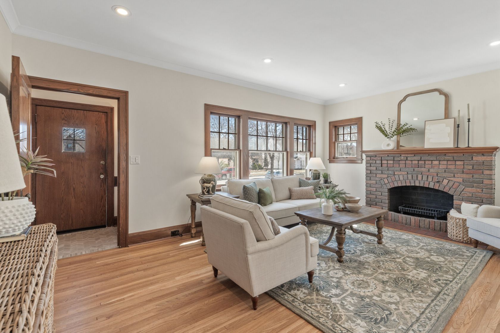 Living room with refinished oak floors and original brick fireplace